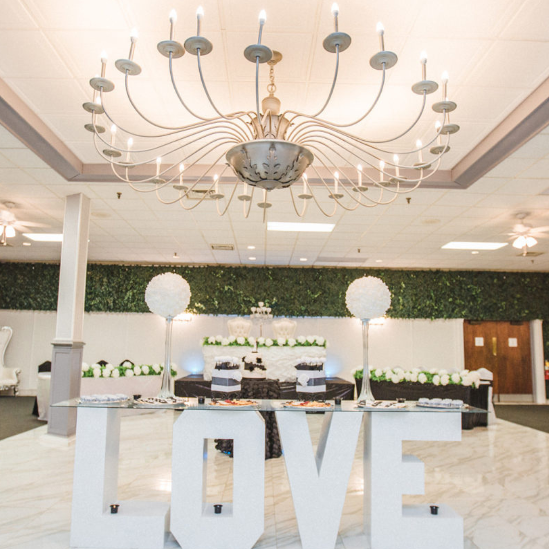 Elegant Amethyst Ballroom at Prestige Banquet Hall decorated with chandeliers, ivy backdrop, and LOVE display.