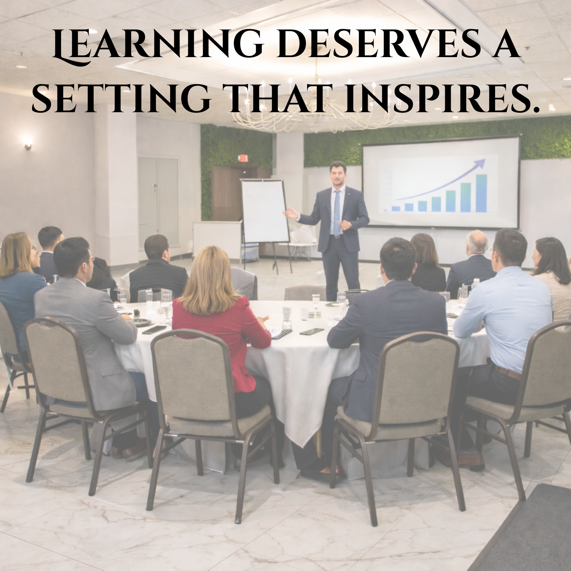 Professional training session set in an elegant banquet hall, with attendees seated at round tables and a presenter speaking at the front under chandeliers.